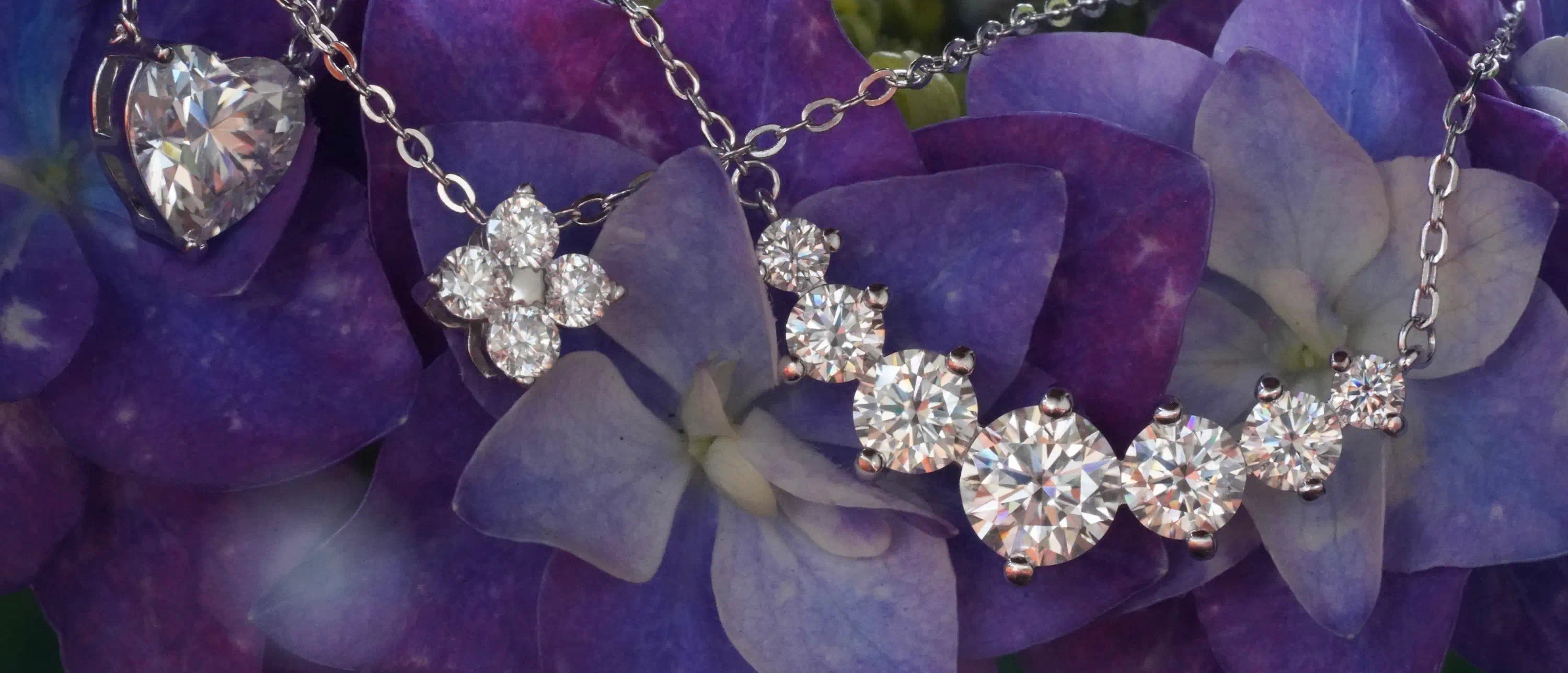 Klar funkelnde Moissanite Ketten mit Moissanite Anhänger aus Sterling Silber an Blumen gelehnt