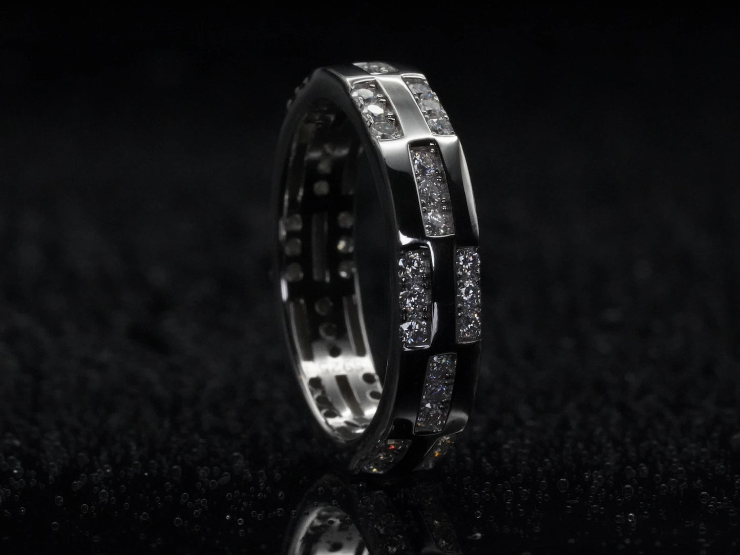 Moissanite-Ring mit Musterstruktur stehend fotografiert – aufrecht präsentiert, zeigt Brillantschliff und dekorative Struktur auf 925 Sterling Silber in voller Klarheit