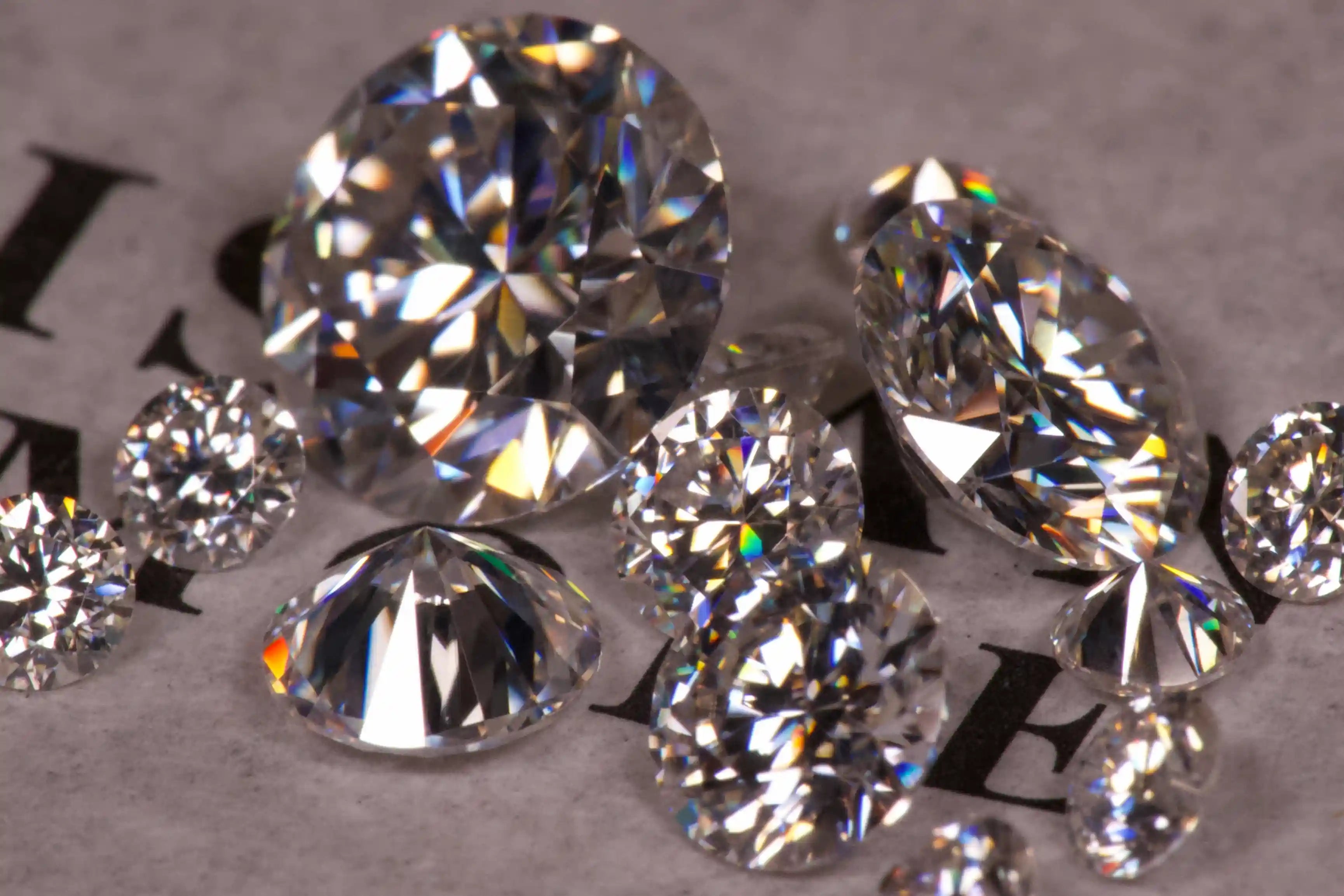 verschiedene Moissanite Steine funkeln im hellen Licht auf weißen Papier