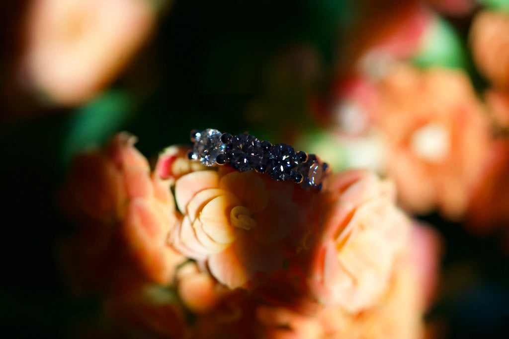 Auffällige Moissanite Schmuck Ohrringe auf einer Orangene Blume im Schatten mit Sonnenlicht