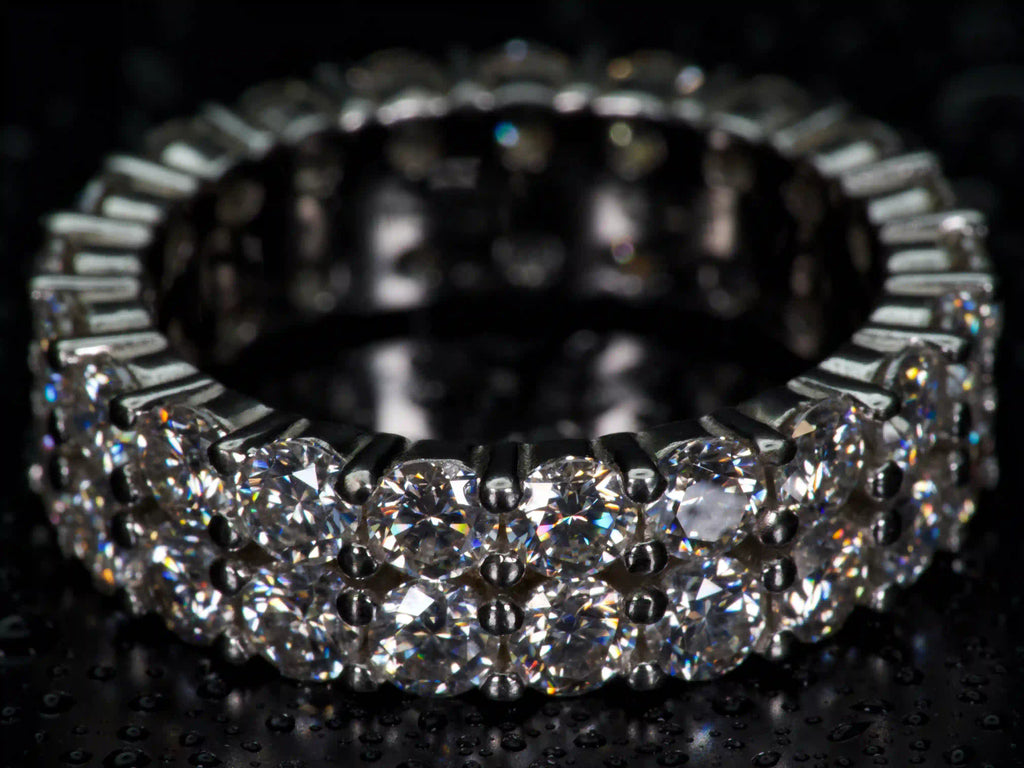 Echte Fotos eines doppelten 3mm Moissanite Eternity Rings aus 925 Silber & Weißgold im echten Licht. Zweireihig gefasste Moissanite mit stärkerem Funkeln als Diamanten erzeugen extreme Lichtreflexe, intensives Feuer und luxuriöse Brillanz aus jedem Winkel. Hochwertiger Eternity Ring mit auffälligem Funkeln und präziser Verarbeitung.