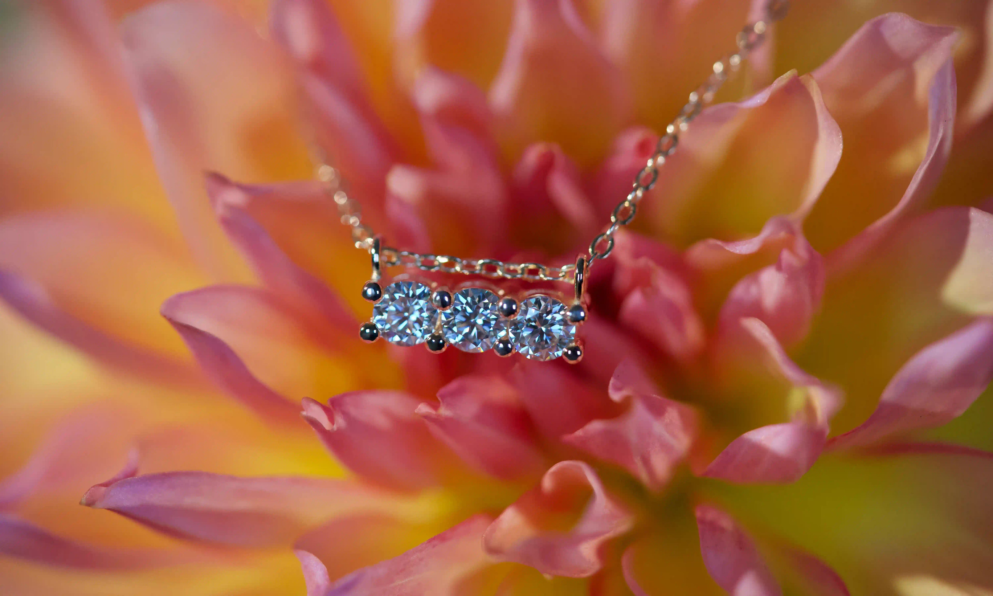 Echte Fotos von Moissanite Anhänger Kette mit 3 funkelnden 3mm Steinen im echten Licht. Intensives Funkeln stärker als bei Diamanten mit sichtbarem Feuer bei Bewegung. Eleganter Moissanite Anhänger aus 925 Silber und Roségold als modernes Geschenk mit diamantähnlicher Härte für den Alltag.