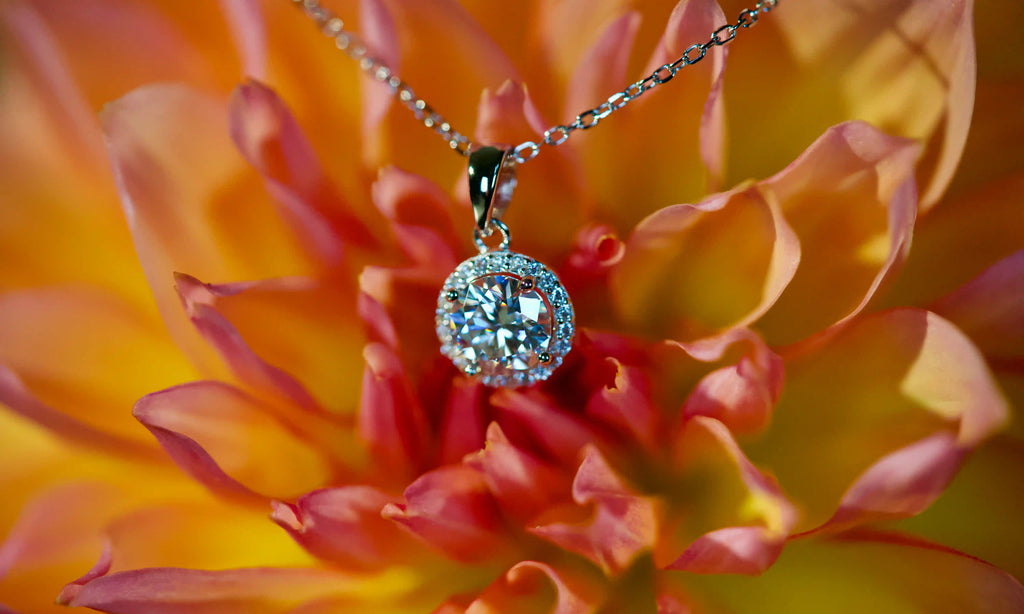 Echte Fotos von Moissanite Halo Anhänger Kette mit 1ct Stein im echten Licht. Intensives Funkeln stärker als bei Diamanten mit sichtbarem Regenbogen Feuer durch den runden Halo Anhänger. Elegante Moissanite Kette aus 925 Silber und 18K Weißgold mit diamantähnlicher Härte als luxuriöses Geschenk für jeden Tag.
