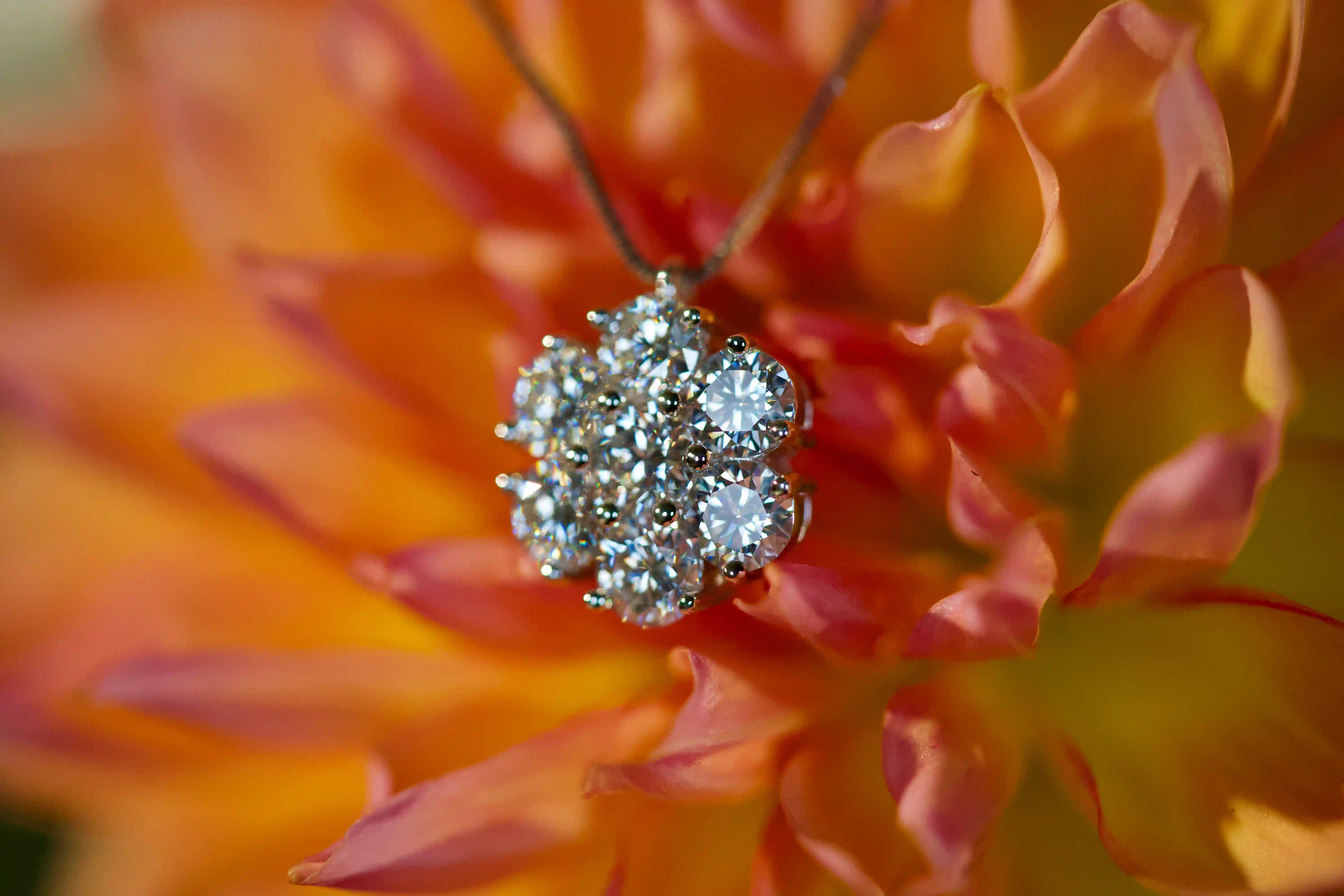 Echte Fotos von iced out Moissanite Cluster Anhänger Kette mit 3,5ct im echten Licht. Sieben 5mm Moissanite erzeugen starkes Funkeln und sichtbares Regenbogen Feuer stärker als bei Diamanten. Luxuriöser iced out Anhänger aus 925 Silber und 18K Weißgold mit diamantähnlicher Härte als auffälliger Statement Schmuck.