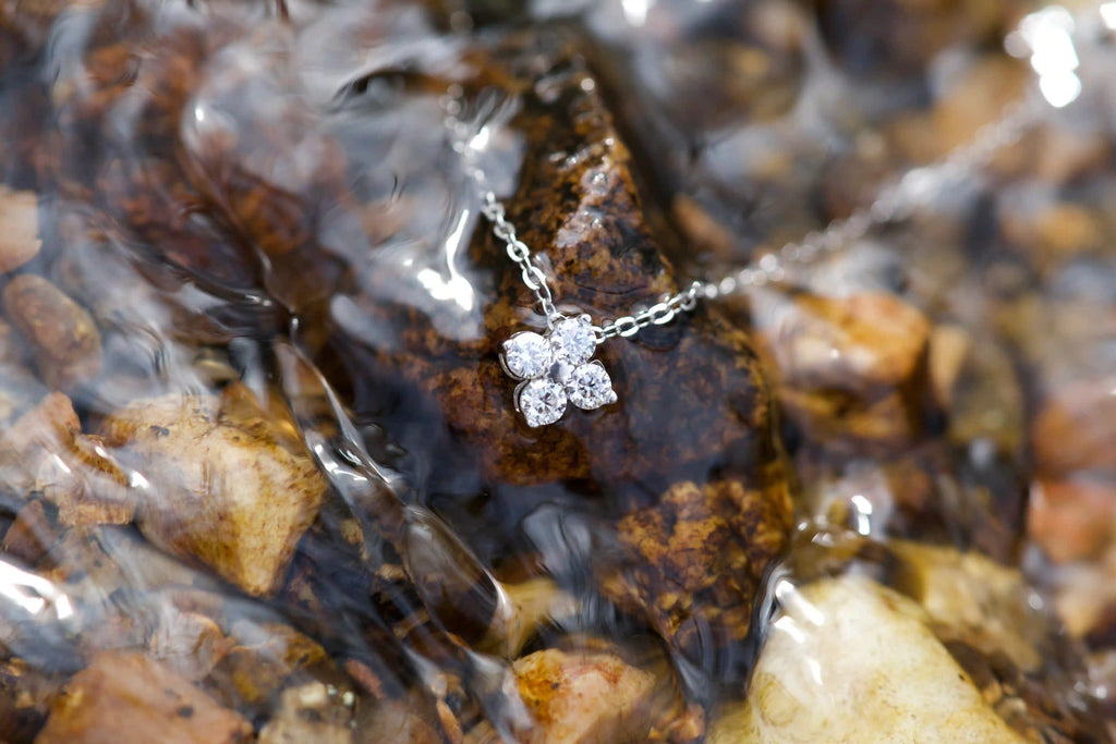 Kleeblatt Moissanit Anhänger mit 3mm Steinen unter Wasser im Bach – echtes Lichtspiel und Funkeln im Alltag ohne KI fotografiert