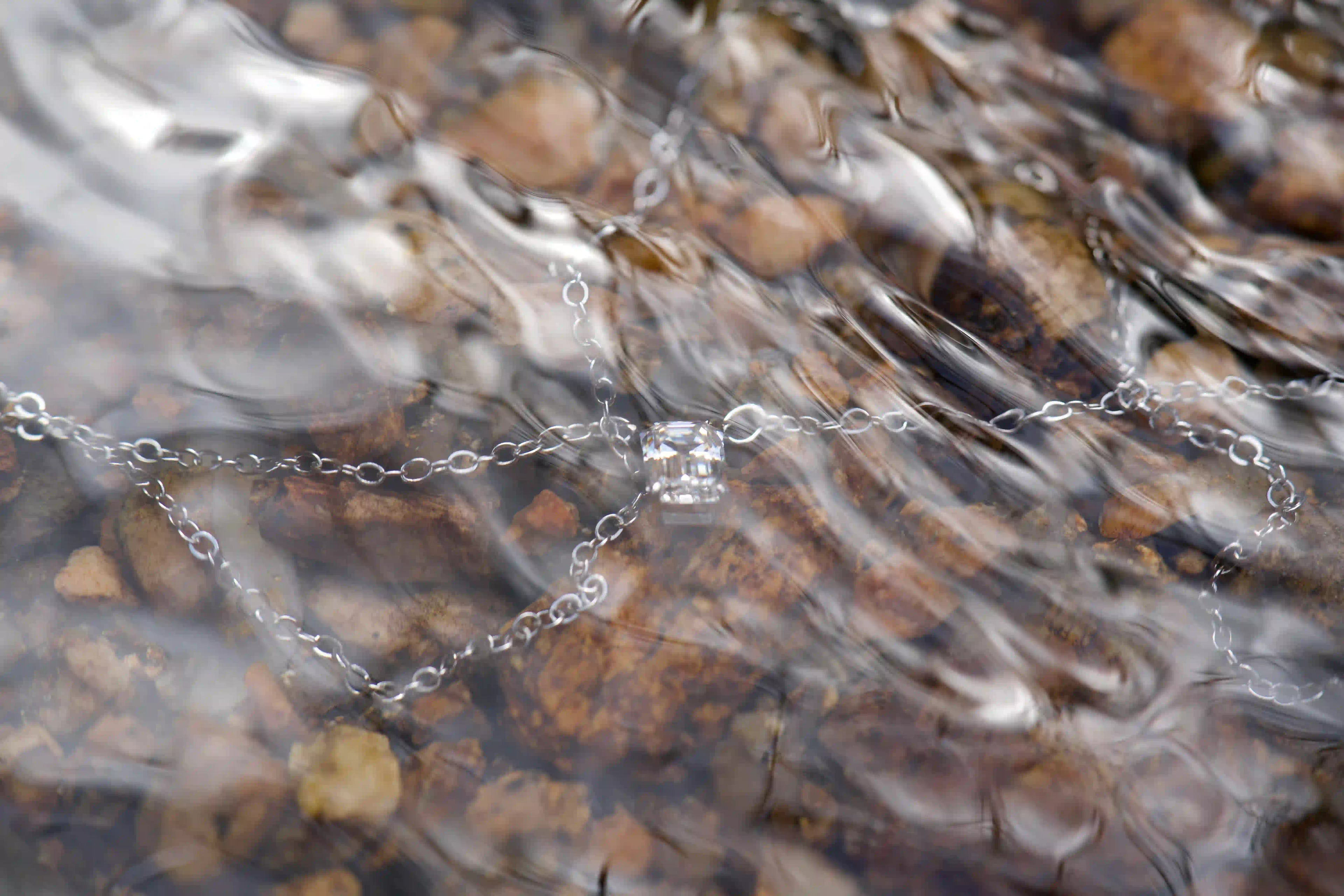 Smaragdschliff Moissanit Anhänger unter Wasser fotografiert – echte Makroaufnahme ohne KI mit natürlichem Funkeln im Tageslicht, 925 Silber Weißgold Veredelung