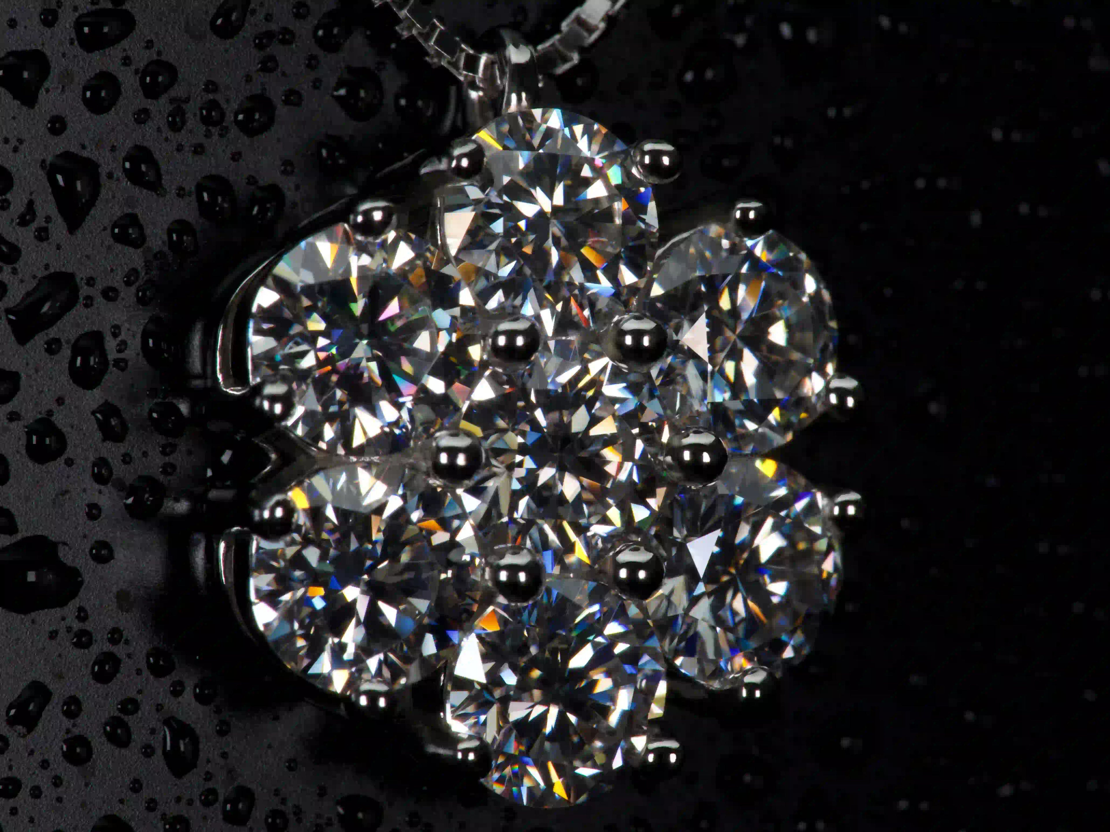 Seitliche Makroaufnahme der Moissanit Cluster Kette im echten Licht. Die 5mm Brillantschliff Moissanite erzeugen stärkeres Funkeln als Diamanten und zeigen intensive Lichtbrechung im Alltag.