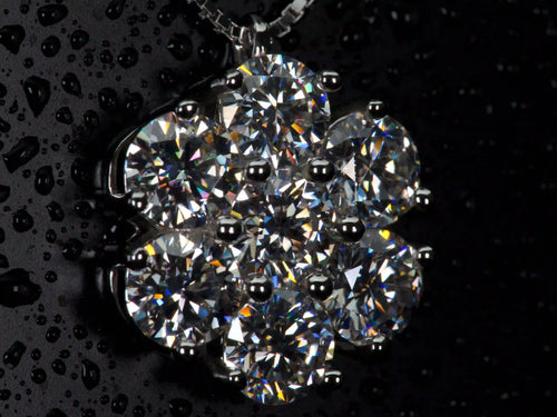 Seitliche Makroaufnahme der Moissanit Cluster Kette im echten Licht. Die 5mm Brillantschliff Moissanite erzeugen stärkeres Funkeln als Diamanten und zeigen intensive Lichtbrechung im Alltag.