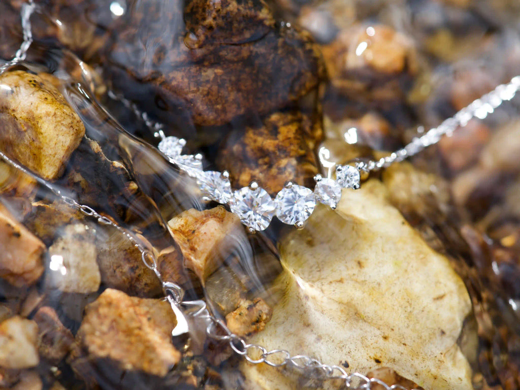 Moissanit Kette mit Größenverlauf unter Wasser im Bach fotografiert – echte Makroaufnahme zeigt klares Funkeln im natürlichen Licht, 925 Silber mit Weißgold Veredelung