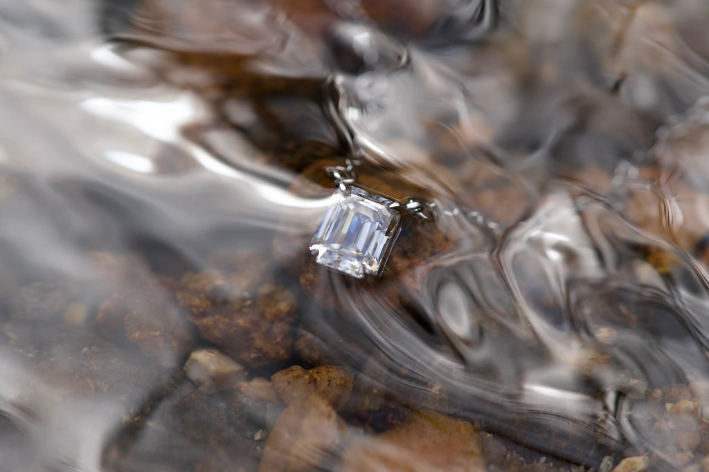 Moissanit Kette Smaragdschliff im fließenden Wasser aus anderem Winkel – echtes Lichtspiel im Bach zeigt klares Funkeln mit diamantähnlicher Brillanz, 925 Silber