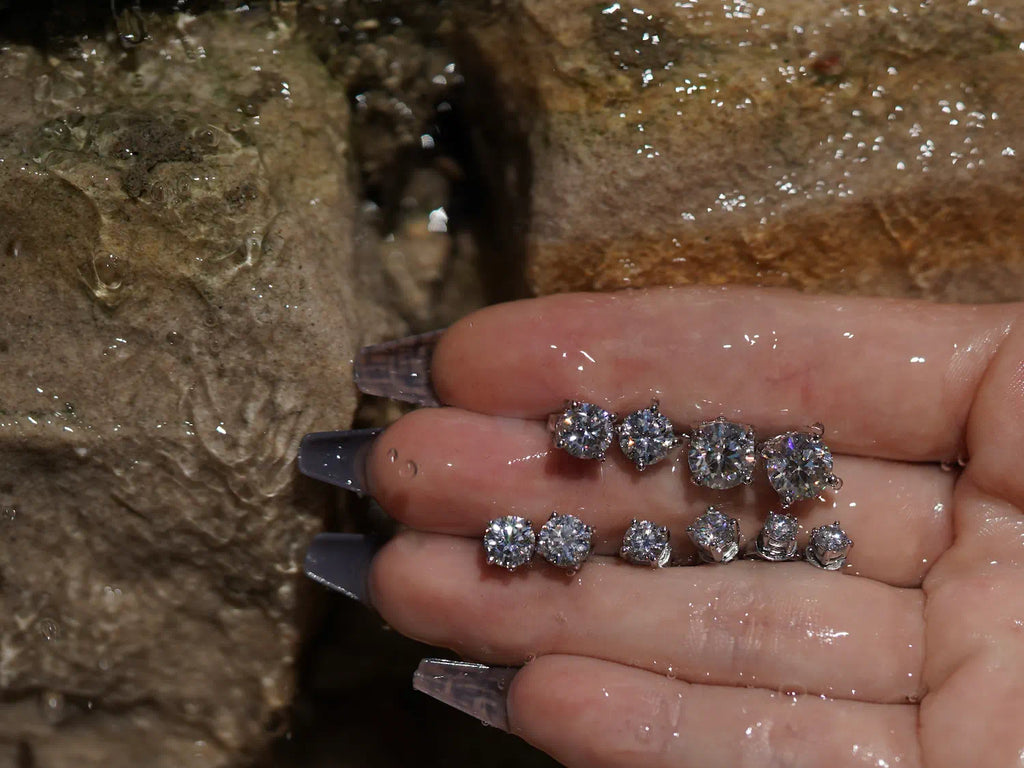 Moissanite Ohrstecker vor Sandsteinwand – präzise geschliffene Moissanite Ohrringe aus Sterling Silber mit Weißgold, dezenter Moissanite Schmuck mit starker Ausstrahlung.