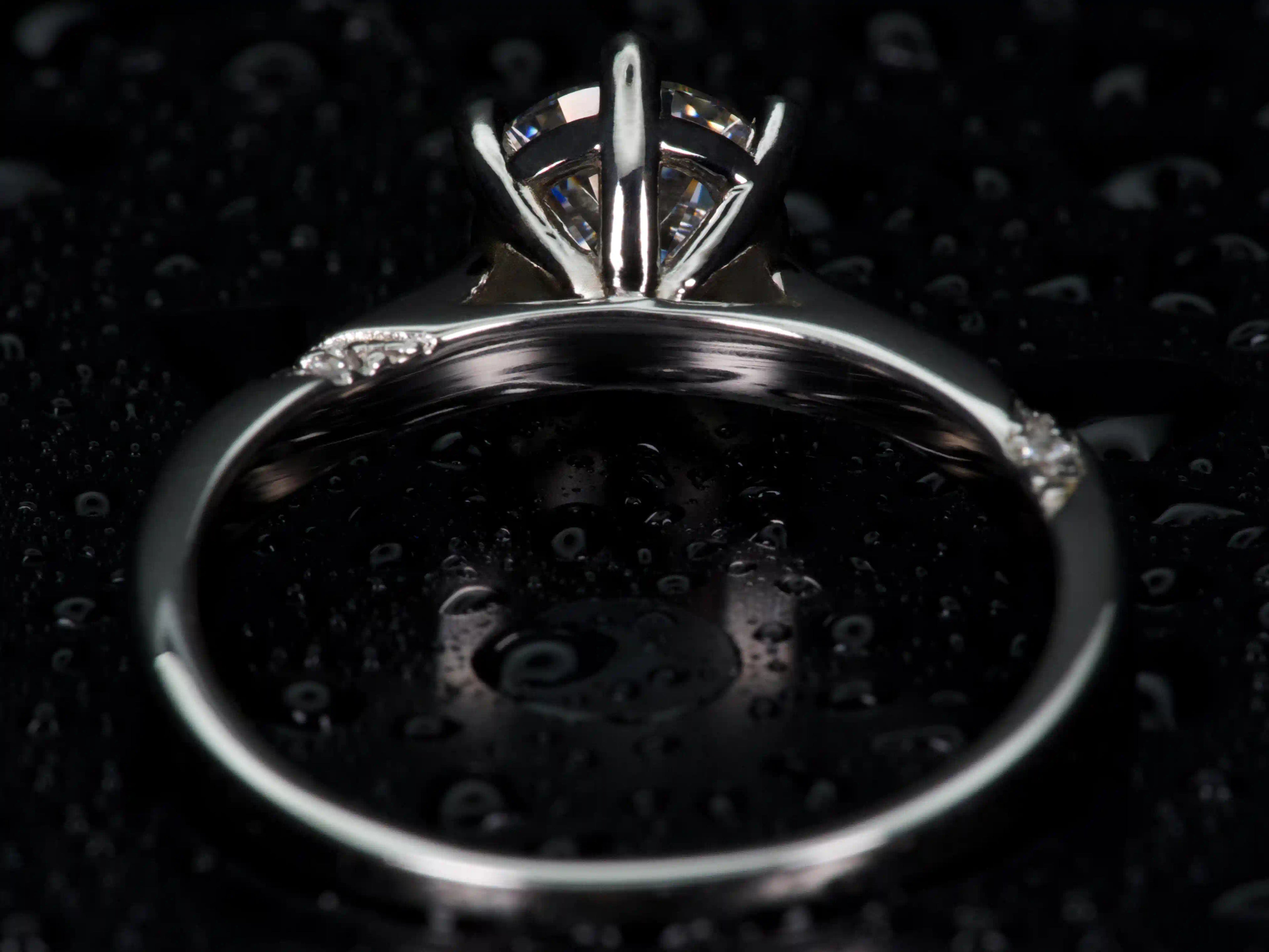 Echte Makroaufnahme: 1ct Moissanit Solitär Ring von der Rückseite – feine Krappenfassung in 925 Silber & Weißgold, präzise Verarbeitung, echtes Licht zeigt klares Funkeln wie Diamant