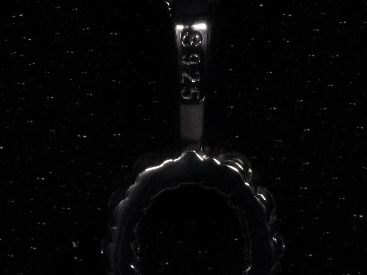 Echte Makroaufnahme der Rückseite einer Moissanite Ankh Kette mit S925 Stempel – offene Fassung für optimalen Lichtdurchlass und sichtbarer Nachweis für 925 Sterling Silber mit Weißgold Veredelung