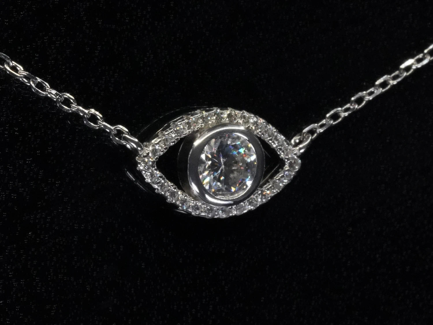 Seitliche Ansicht des Auge-Anhängers – zeigt gewölbte Form, zentrales Funkeln des Moissanite-Steins in stilisiertem Auge-Design aus Silber