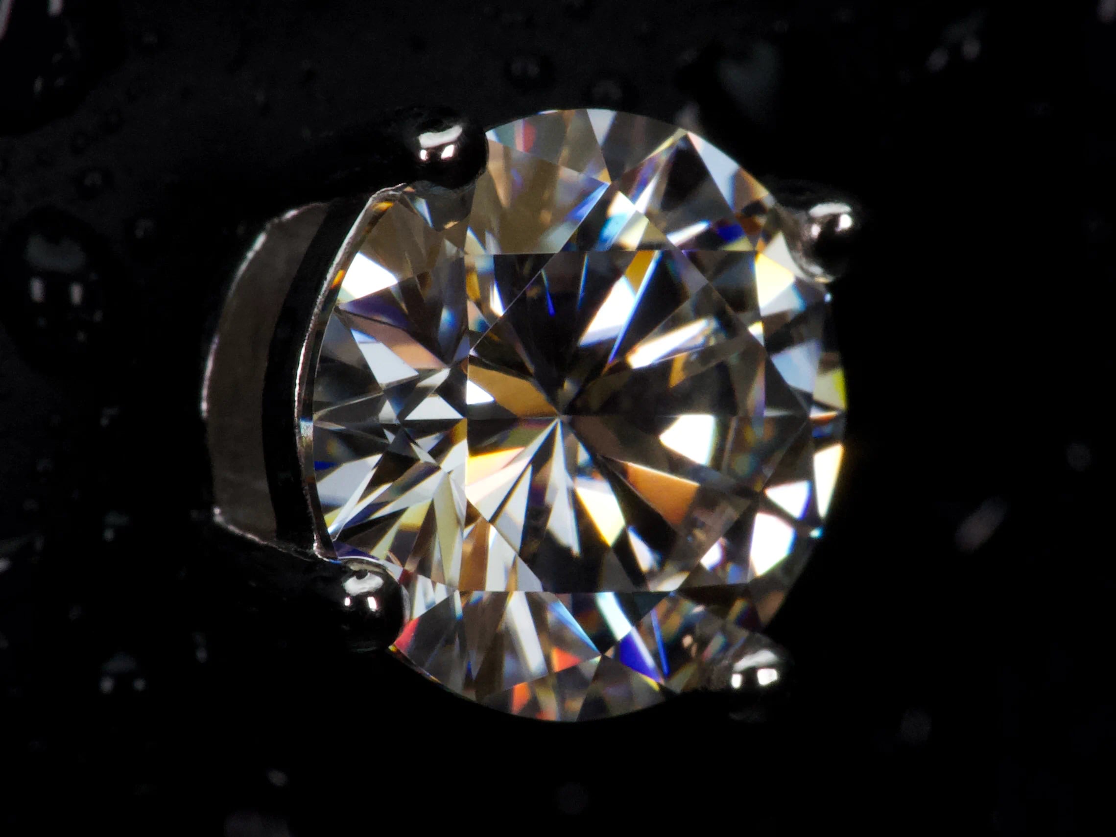 Echte Makroaufnahme eines 2ct Moissanite Brillanten mit extremem Funkeln und starkem Feuer – sichtbar intensiver als Diamant, klare Facettenstruktur, 925 Sterling Silber mit Weißgold Veredelung