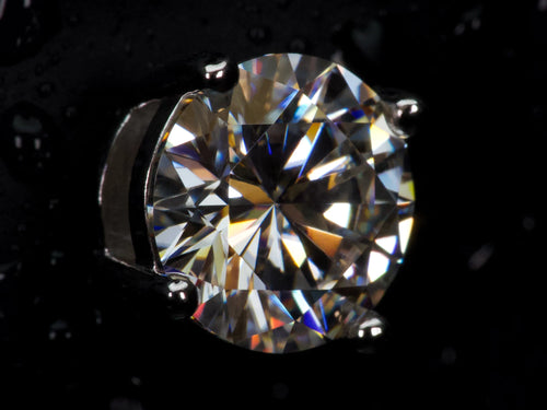 Echte Makroaufnahme eines 2ct Moissanite Brillanten mit extremem Funkeln und starkem Feuer – sichtbar intensiver als Diamant, klare Facettenstruktur, 925 Sterling Silber mit Weißgold Veredelung