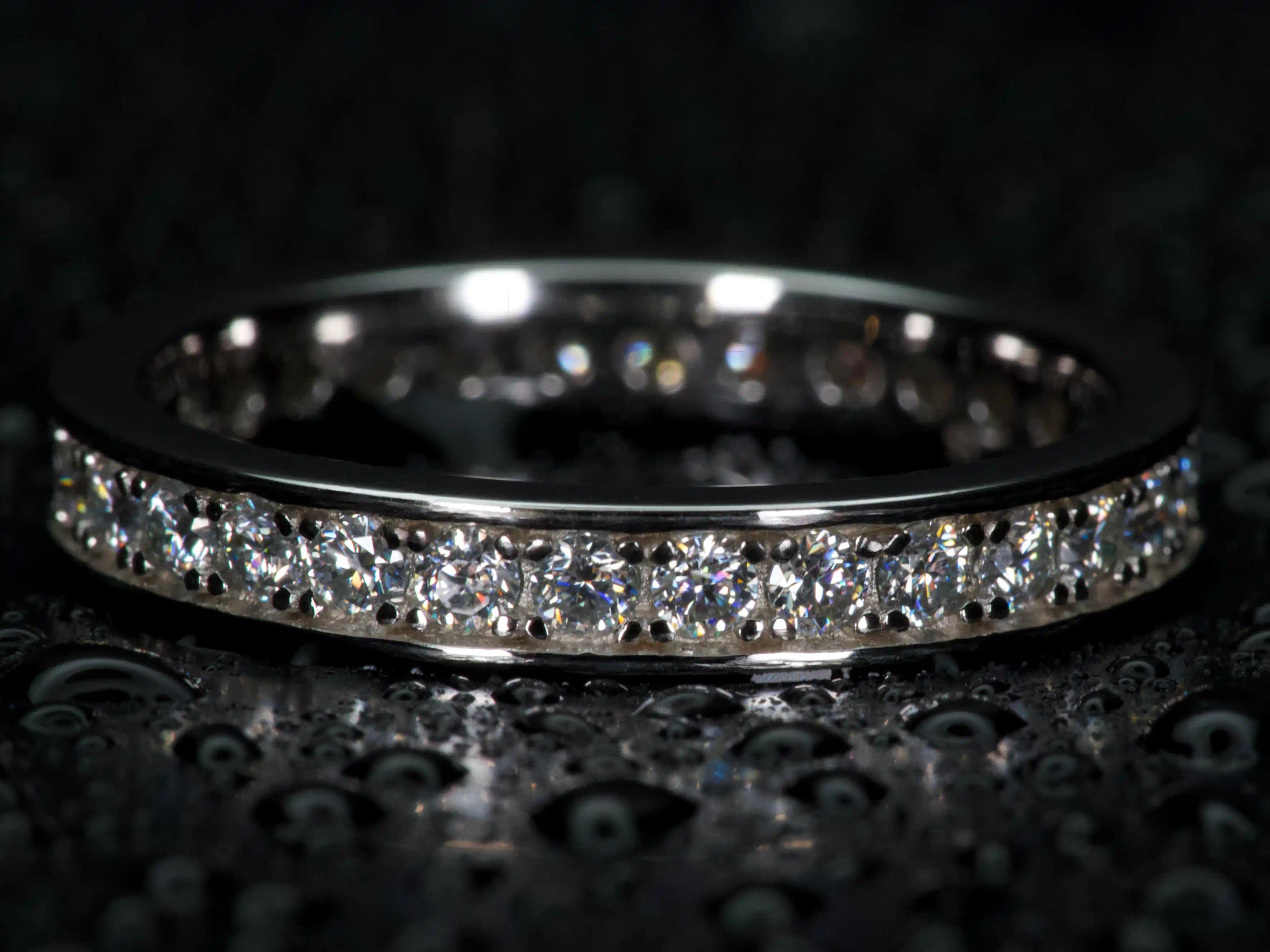 Moissanite Eternity Ring 2 mm mit Rand im Vergleich zu einem 2 ct Moissanite – sichtbares Funkeln und Größenunterschied, echte Makroaufnahme