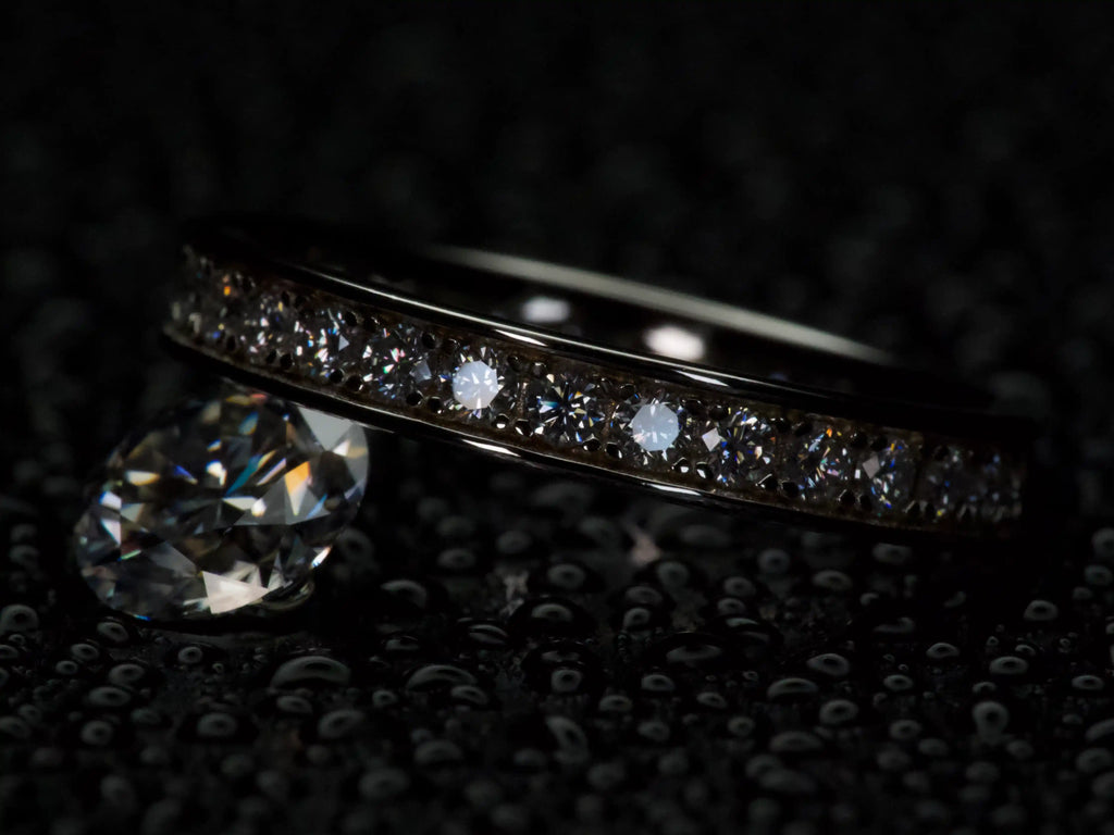 Größenvergleich zwischen einem Moissanite Eternity Ring mit 2 mm Steinen und einem 2 ct Moissanite – sichtbarer Unterschied in Größe und Funkeln, echte Makroaufnahme