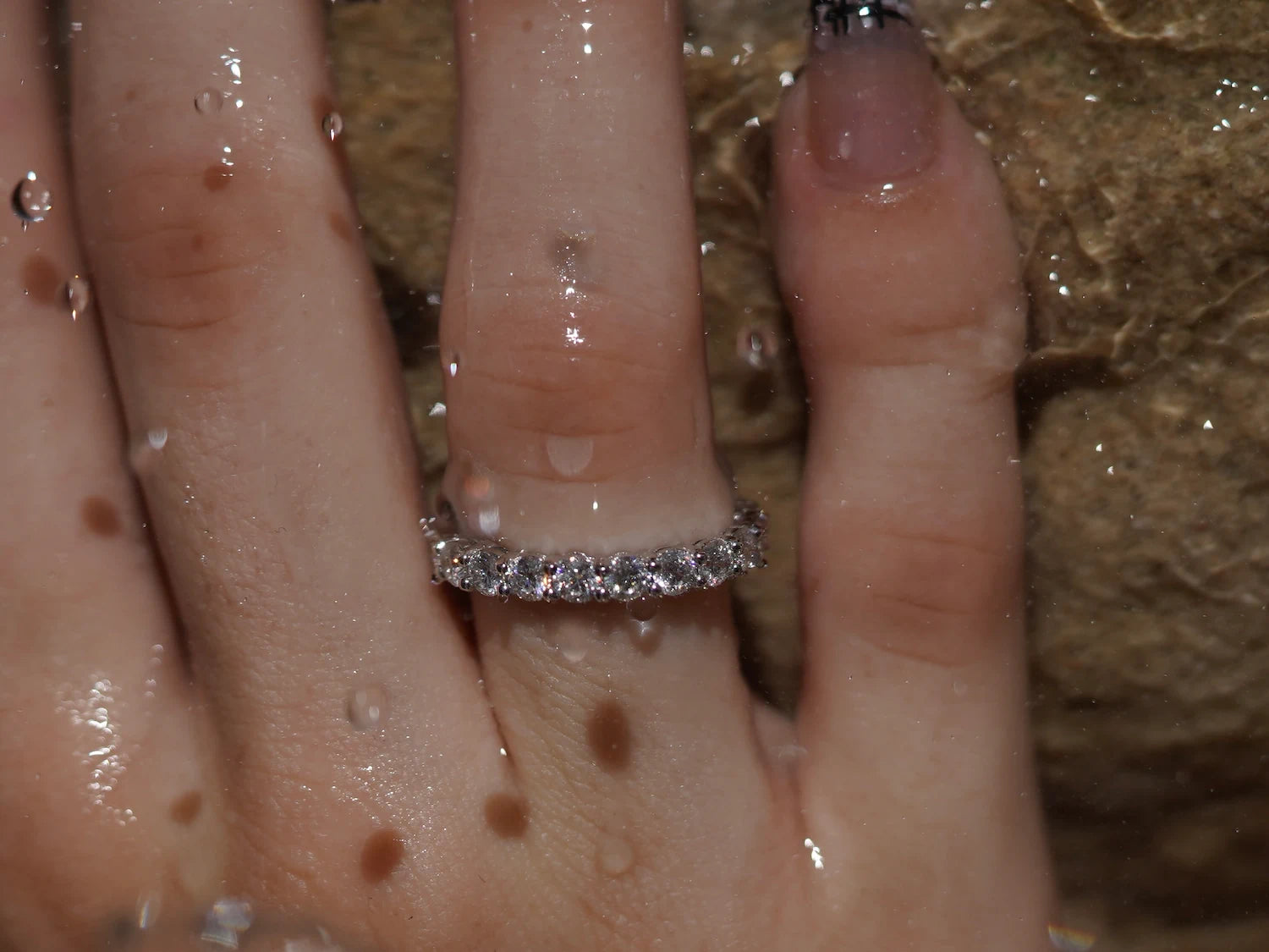 Moissanite Ring mit durchgehenden Rundsteinen aus Sterling Silber mit Weißgold – gleichmäßiger Moissanite Schmuck im Wasserlicht mit klarer Struktur und Präzision.