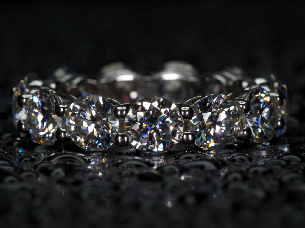 Moissanite Eternity Ring mit großen 5 mm Steinen frontal aufgenommen, intensives Funkeln bei echtem Licht, 925 Silber & 18K Weißgold, echte Fotos ohne KI