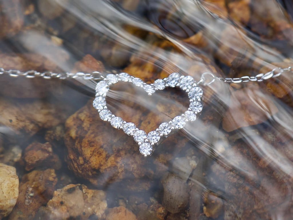 Moissanite Herz Kette mit 2mm Steinen unter Wasser – echte Fotos zeigen intensives Funkeln im natürlichen Licht, feine Lichtreflexe durch Bewegung sichtbar, 925 Silber mit Weißgold Veredelung