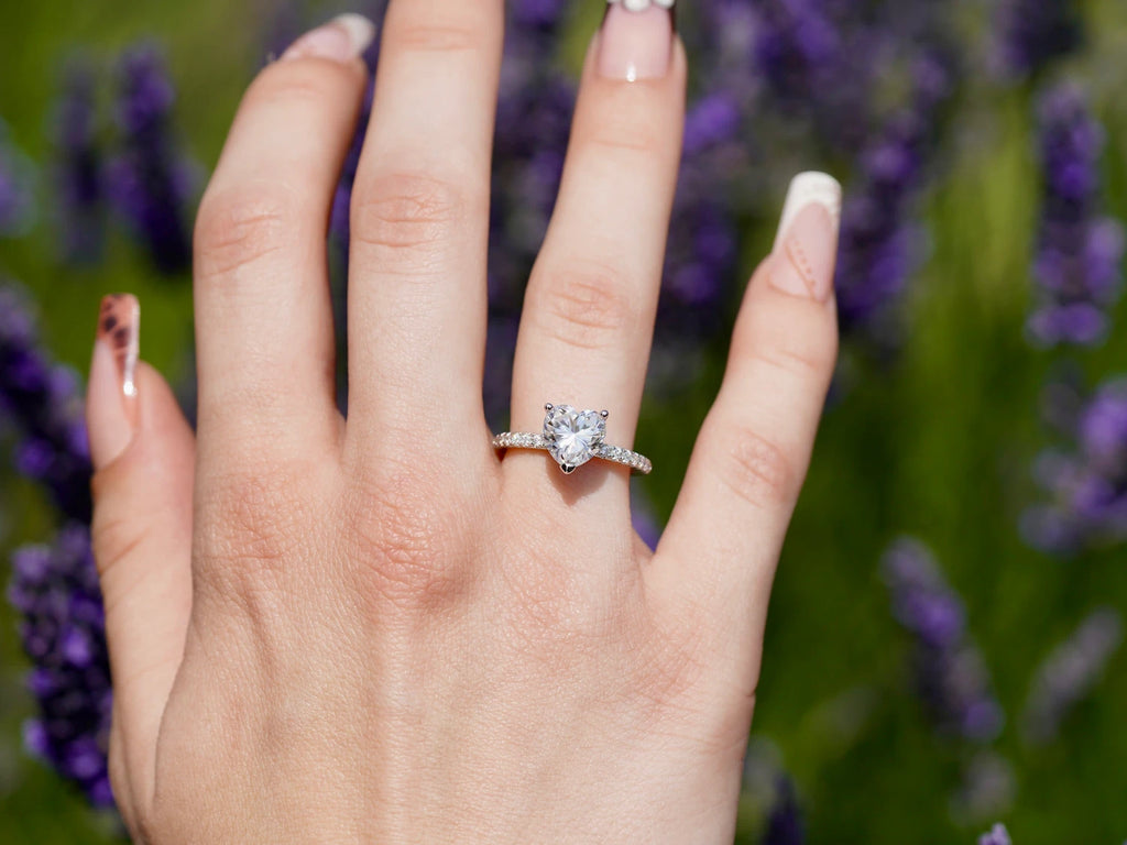 Funkelnder Moissanit Herz Ring auf der Hand getragen im Feld