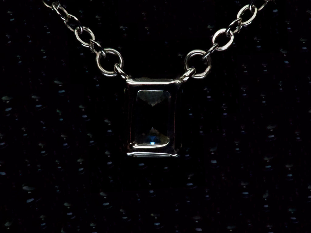 Echte Makroaufnahme der Rückseite einer Moissanite Kette mit 2ct Smaragdschliff – offene Fassung für maximalen Lichtdurchlass und klare Tiefenwirkung, gefertigt aus 925 Sterling Silber mit Weißgold Veredelung