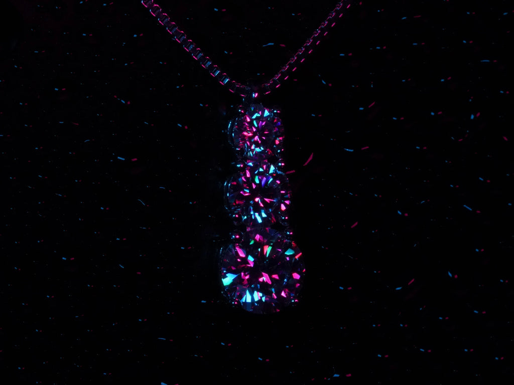 Strahlende Moissanite Anhänger mit 3 Moissanite in Lila und blauem Licht.