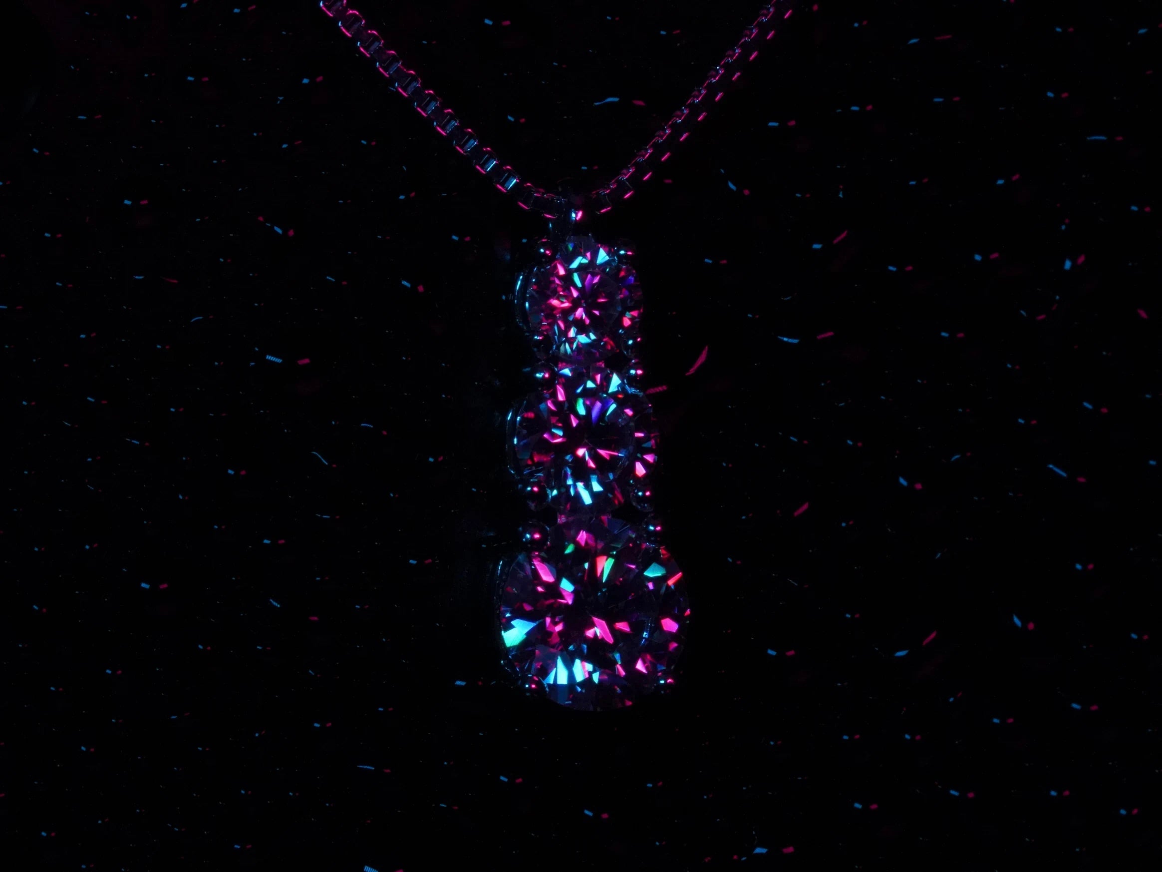 Strahlende Moissanite Anhänger mit 3 Moissanite in Lila und blauem Licht.
