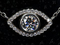 Echte Macro Aufnahme einer Moissanite Kette mit Auge Anhänger – zentraler Stein mit extremem Funkeln und Feuer im echten Licht, umgeben von feinem Halo, 925 Sterling Silber mit Weißgold Veredelung, auffälliger als Diamant im Vergleich