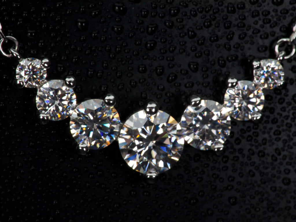 Echte Macro Fotos einer Moissanite Kette mit Größenverlauf aus 6 Steinen – zentraler großer Stein mit abgestuften kleineren Steinen, intensives Funkeln und Feuer im echten Licht, 925 Sterling Silber mit Weißgold Veredelung, auffälliger als Diamant