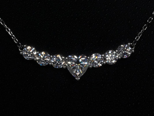 Moissanite-Kette mit Herzschliff – frontal fotografiert, zentraler Moissanite in Herzform mit sechs runden Steinen nebeneinander in gebogener Silberfassung