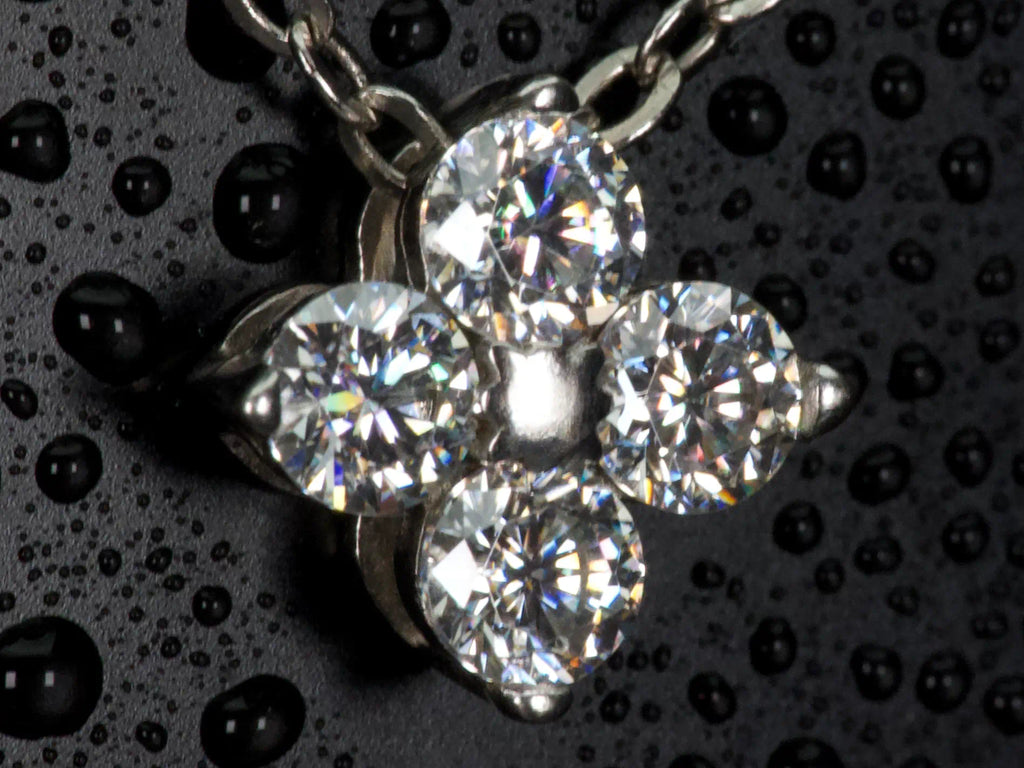 Ultra Makroaufnahme einer Moissanite Kleeblatt Kette – detailreiche Brillant Steine mit starkem Funkeln und Lichtspiel ähnlich Diamanten, echte Aufnahme ohne KI