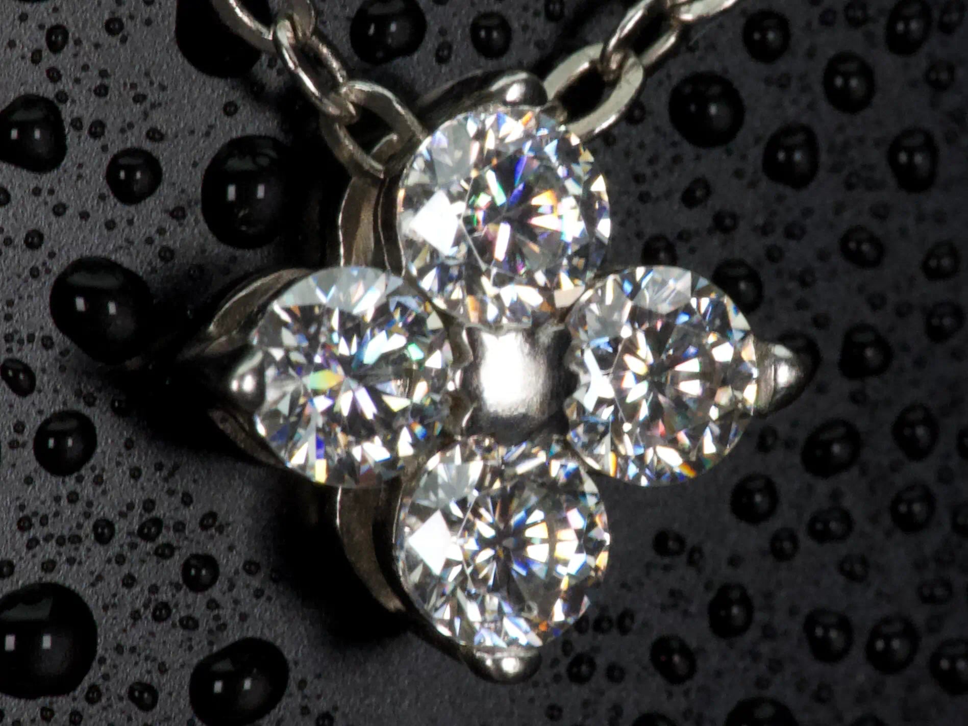 Ultra Makroaufnahme einer Moissanite Kleeblatt Kette – detailreiche Brillant Steine mit starkem Funkeln und Lichtspiel ähnlich Diamanten, echte Aufnahme ohne KI