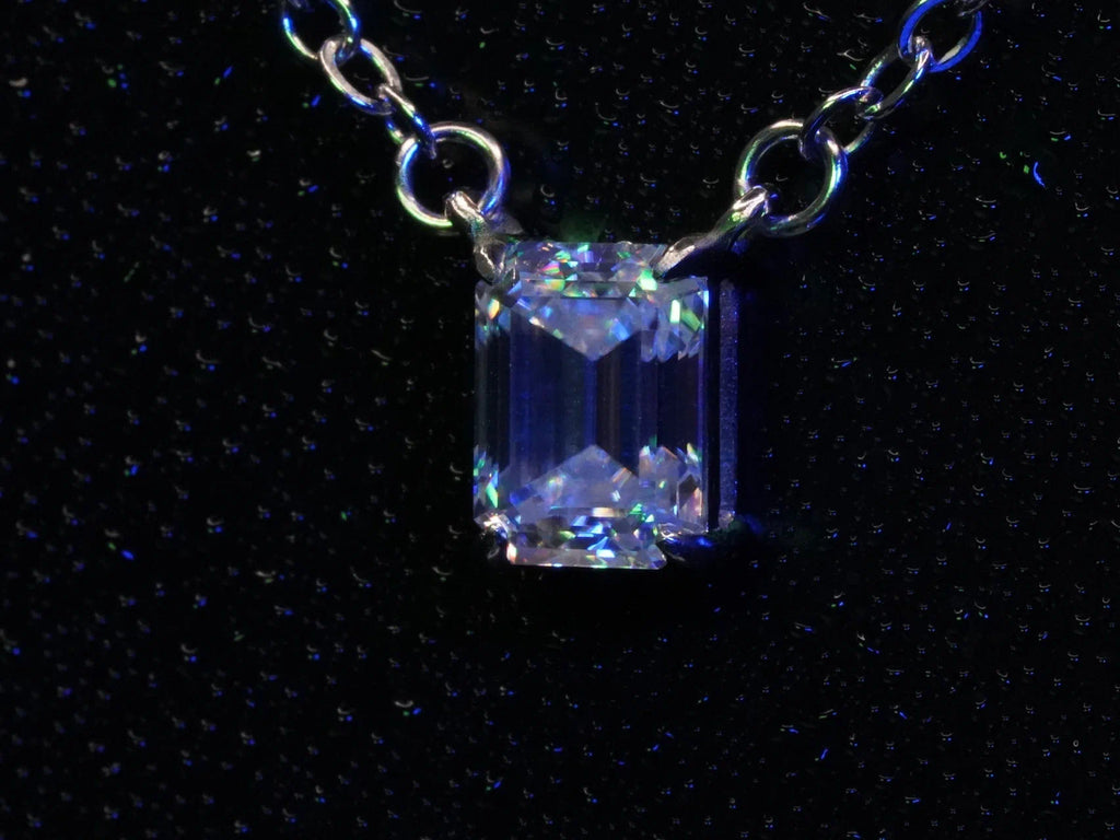 Funkelnder Moissanite Smaragd in Blauem und Grünem Licht an einer Silber Kette