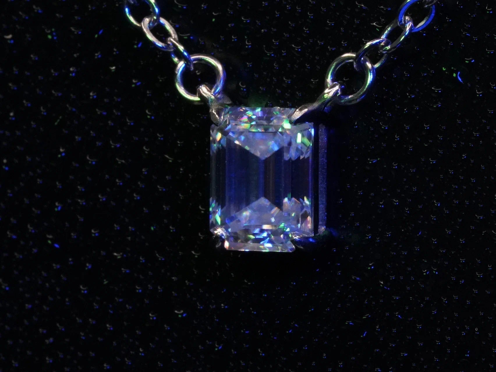 Funkelnder Moissanite Smaragd in Blauem und Grünem Licht an einer Silber Kette