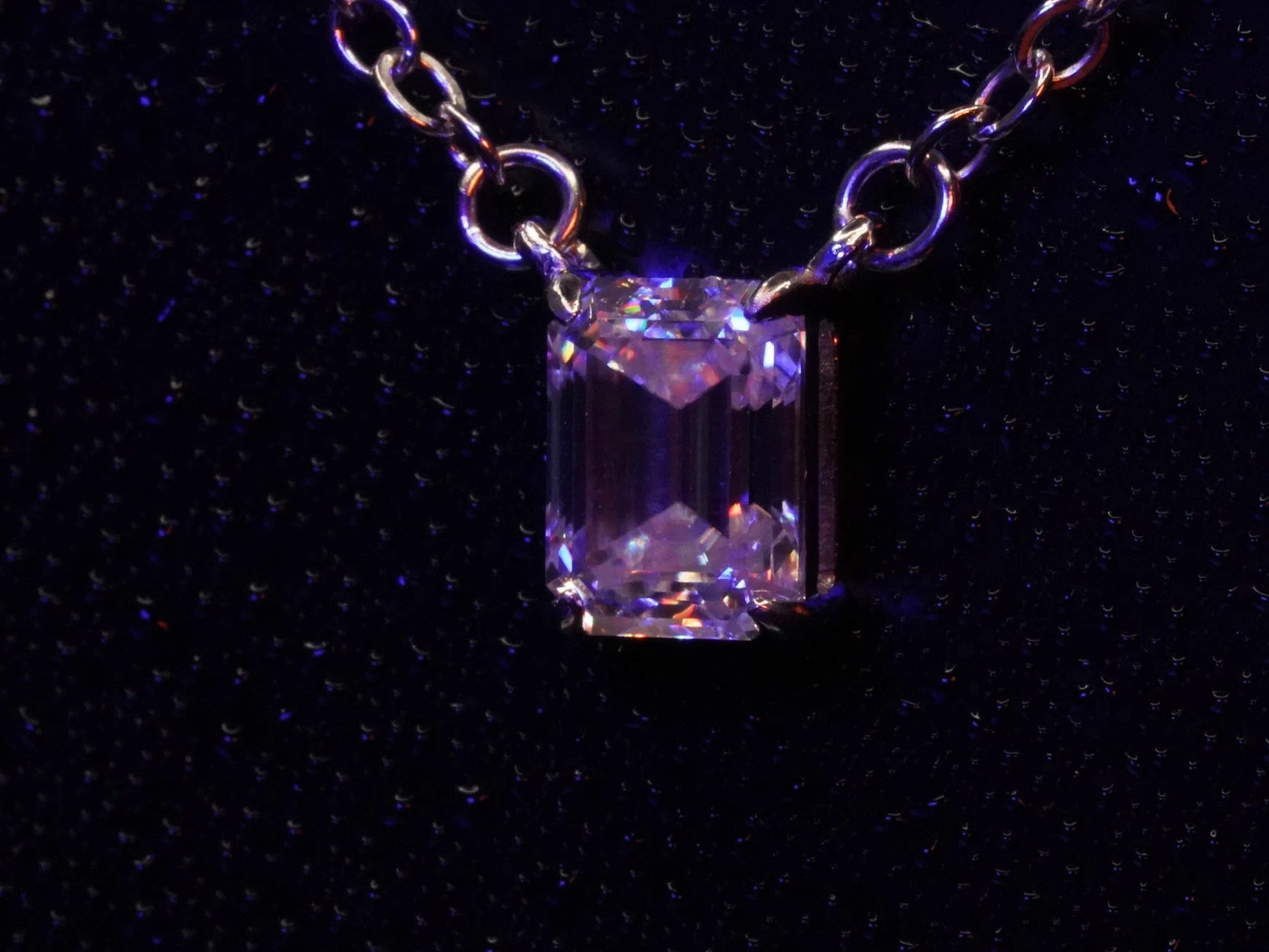 Seitliches Fotos vom Klar funkelnder Moissanite Smaragd Schliff Anhänger an der Silber Kette