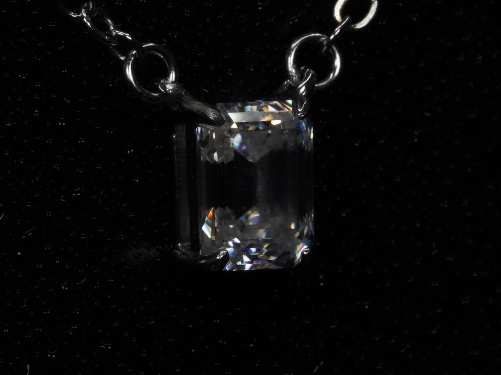 Seitliches Foto vom klaren Moissanite Smaragd Anhänger in Sterling Silber gefasst.