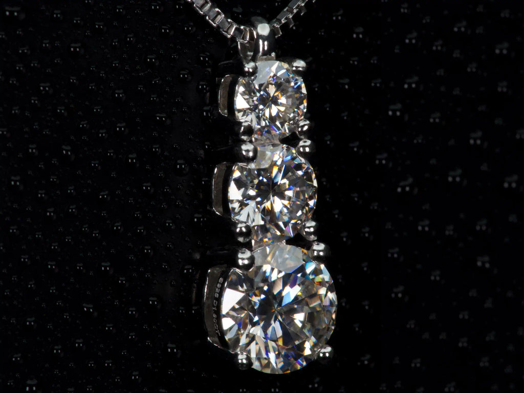 Seitenansicht einer Moissanite Verlauf Kette mit 3 Steinen – offene Fassung für maximalen Lichteinfall und starkes Funkeln ähnlich Diamanten, echte Aufnahme