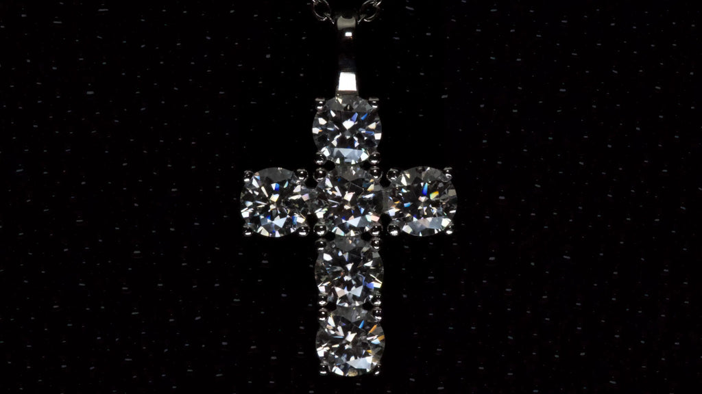 Moissanite Kreuz Anhänger mit 5mm Brillantschliff Steinen aus 925 Silber mit Weißgold Veredelung auf dunklem Hintergrund