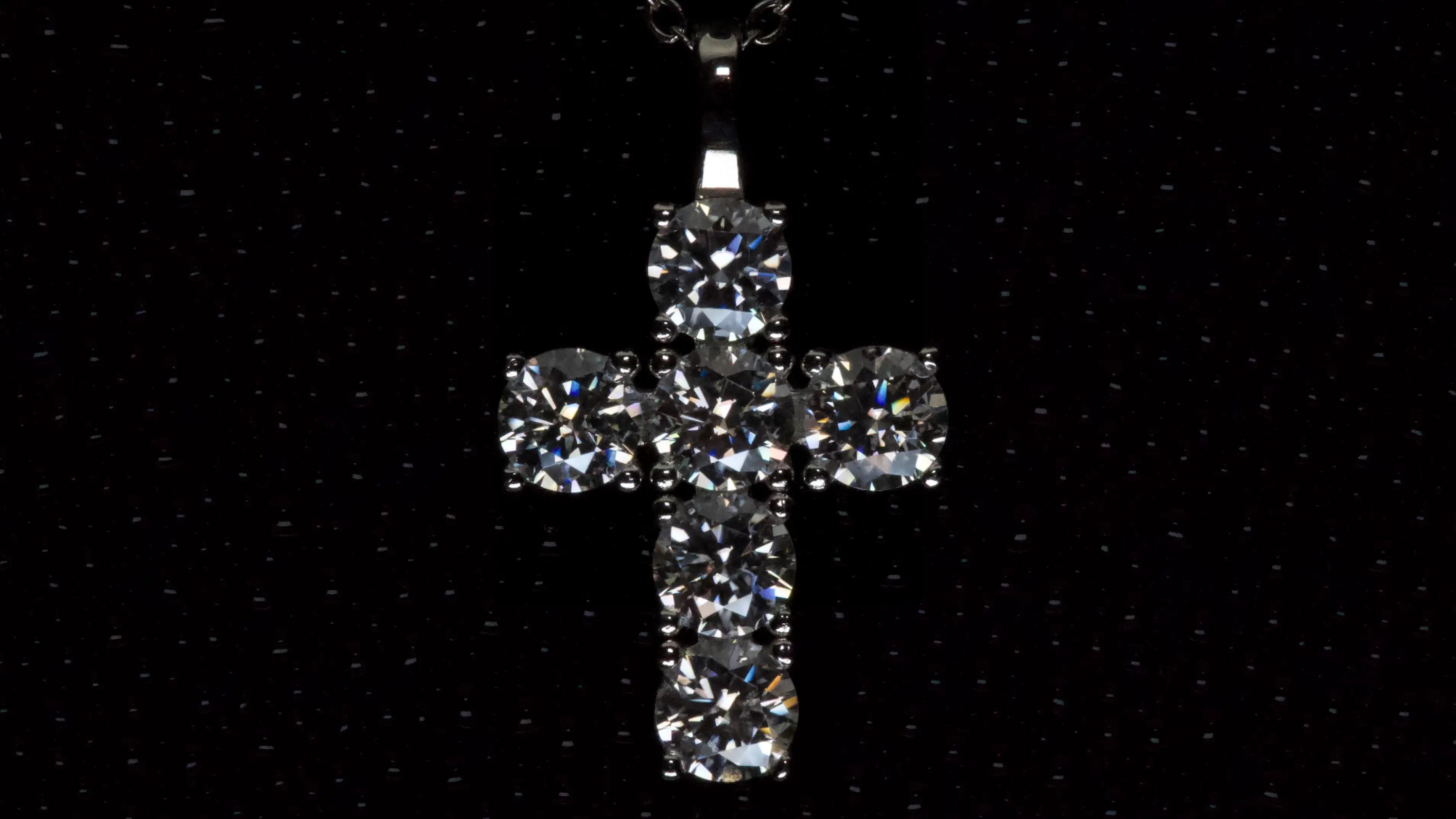 Moissanite Kreuz Anhänger mit 5mm Brillantschliff Steinen aus 925 Silber mit Weißgold Veredelung auf dunklem Hintergrund