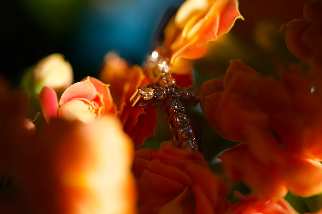 zeitlose moissanite kreuz Ohrringe mit Creolen aus Sterling Silber auf orangenen Blumen abgelegt