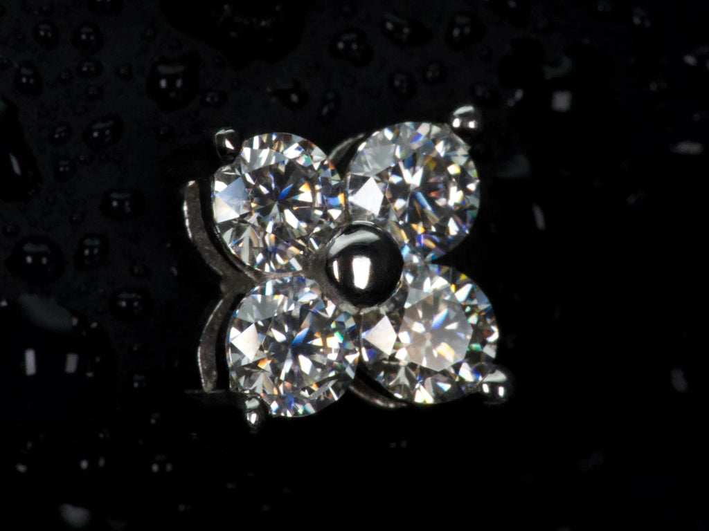 Echte Makroaufnahme eines Moissanite Ohrsteckers im Kleeblatt Design mit 4 Steinen – gleichmäßiges Funkeln und starkes Feuer im Licht, sichtbare Facetten und präzise Fassung, 925 Sterling Silber