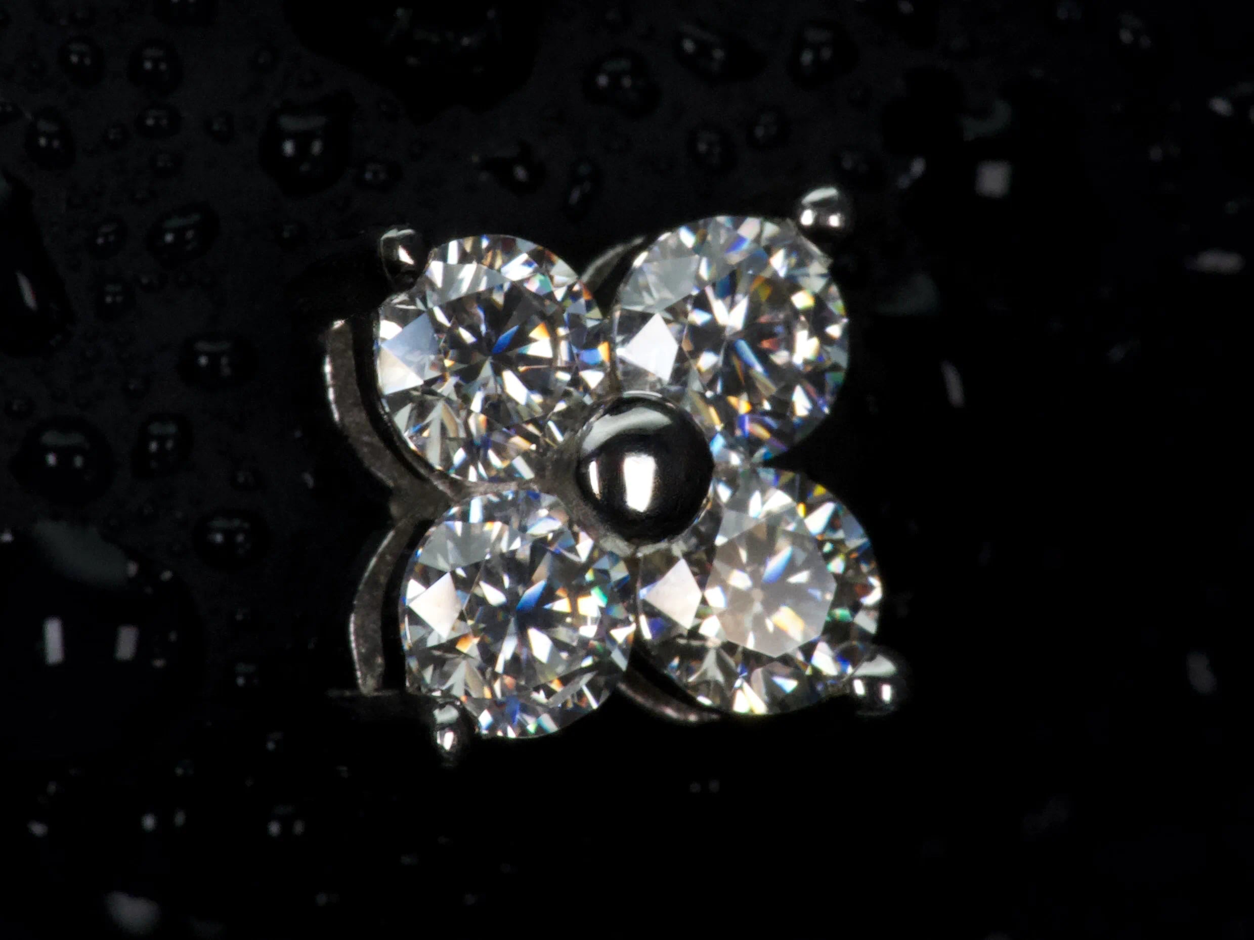 Echte Makroaufnahme eines Moissanite Ohrsteckers im Kleeblatt Design mit 4 Steinen – gleichmäßiges Funkeln und starkes Feuer im Licht, sichtbare Facetten und präzise Fassung, 925 Sterling Silber