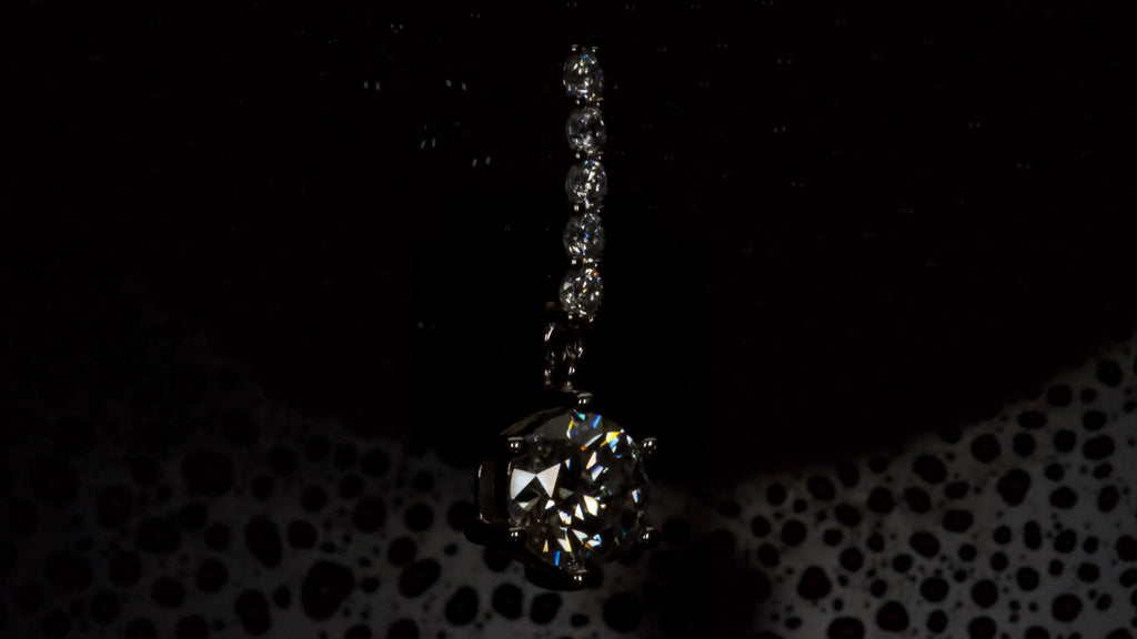 Moissanite Ohrring mit 1ct hängendem Brillantschliff Stein in dunkler Seitenansicht aus 925 Silber mit Weißgold Veredelung