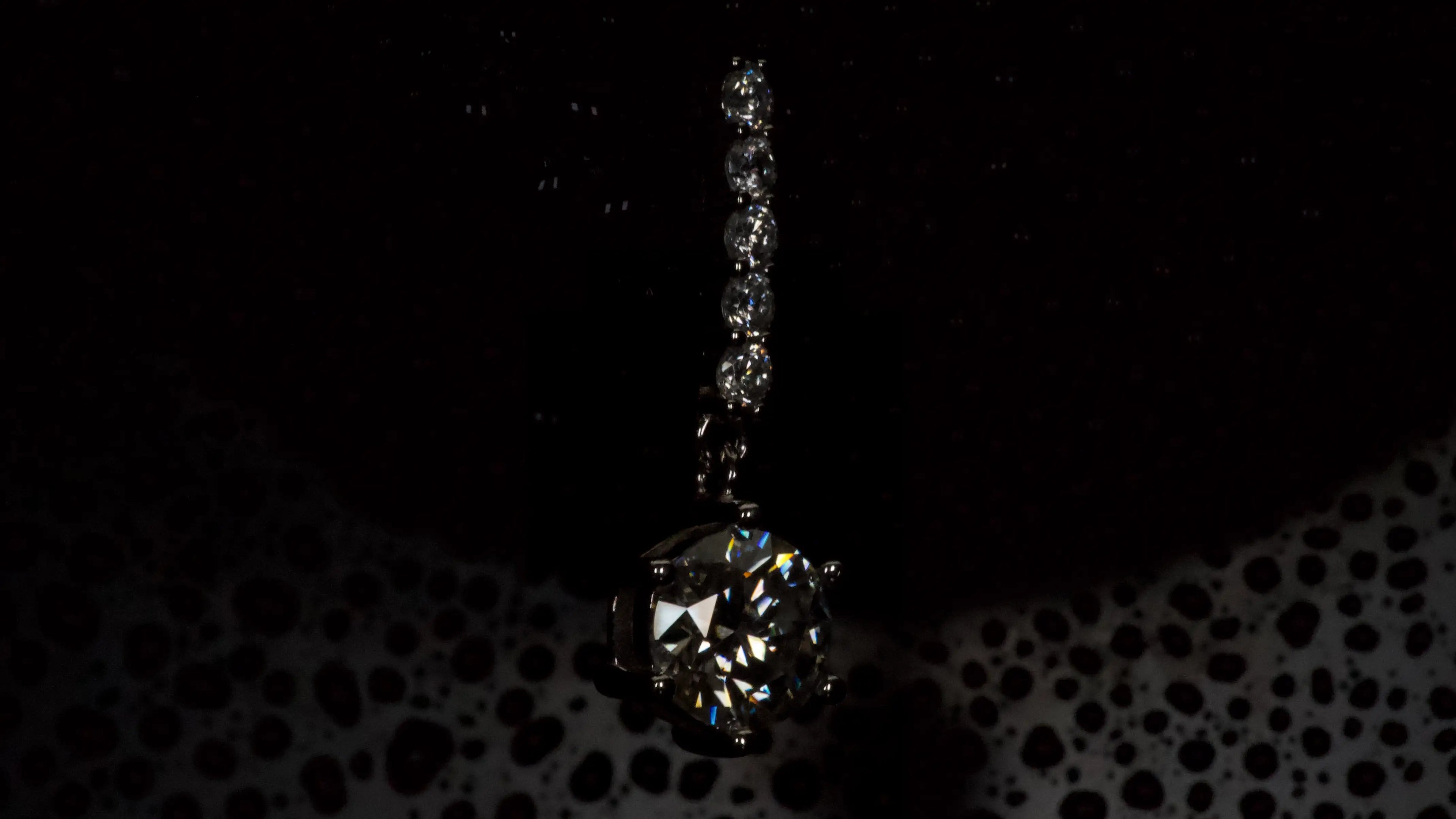 Moissanite Ohrring mit 1ct hängendem Brillantschliff Stein in dunkler Seitenansicht aus 925 Silber mit Weißgold Veredelung