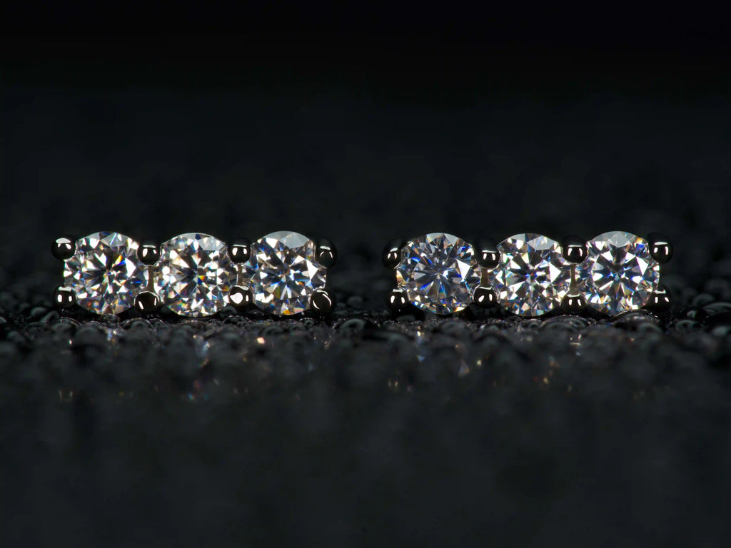 Moissanite Ohrstecker mit 3 Steinen in gerader Reihe im echten Licht mit stärkerem Funkeln als Diamant.