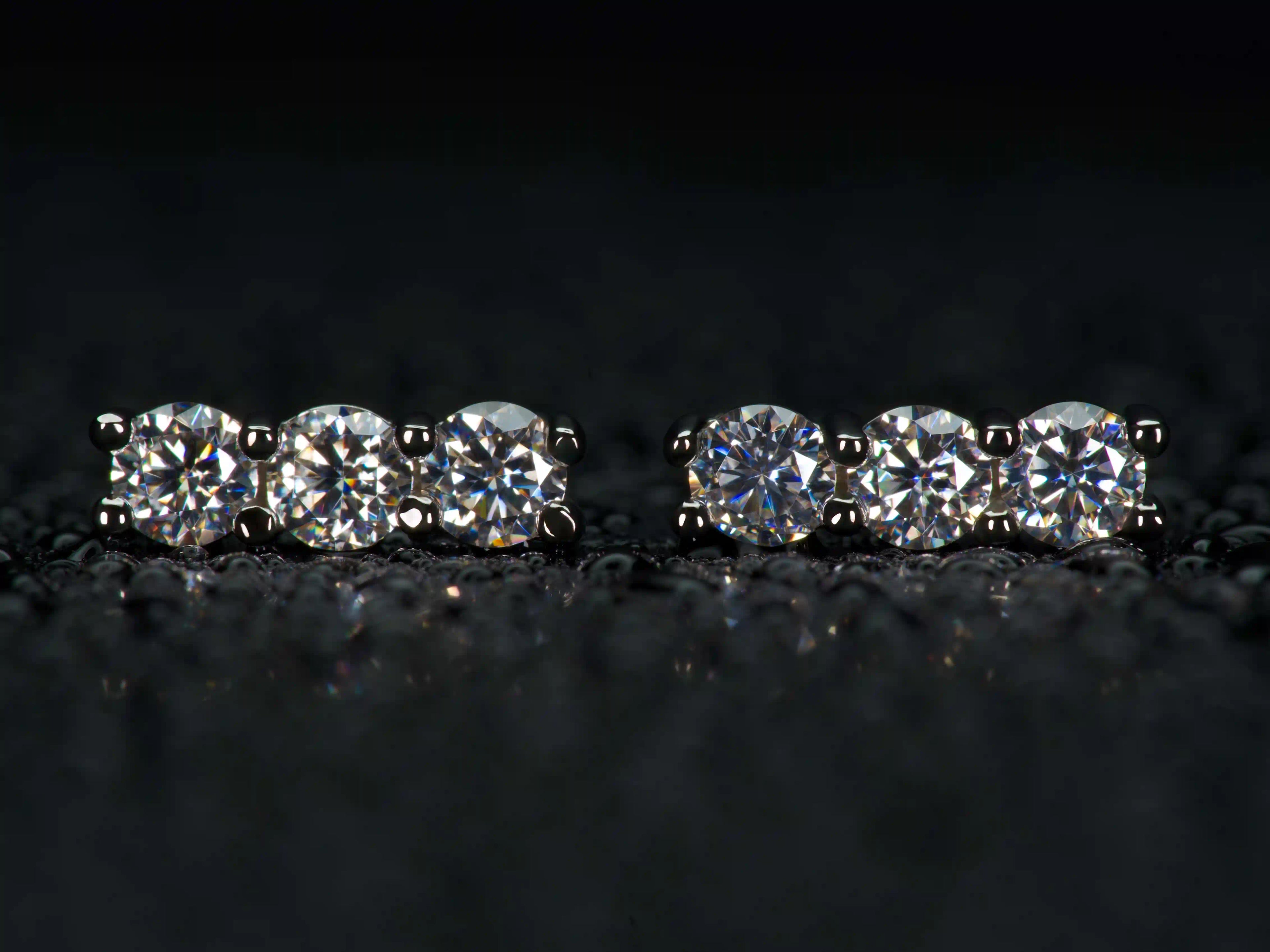 Moissanite Ohrstecker mit 3 Steinen in gerader Reihe im echten Licht mit stärkerem Funkeln als Diamant.