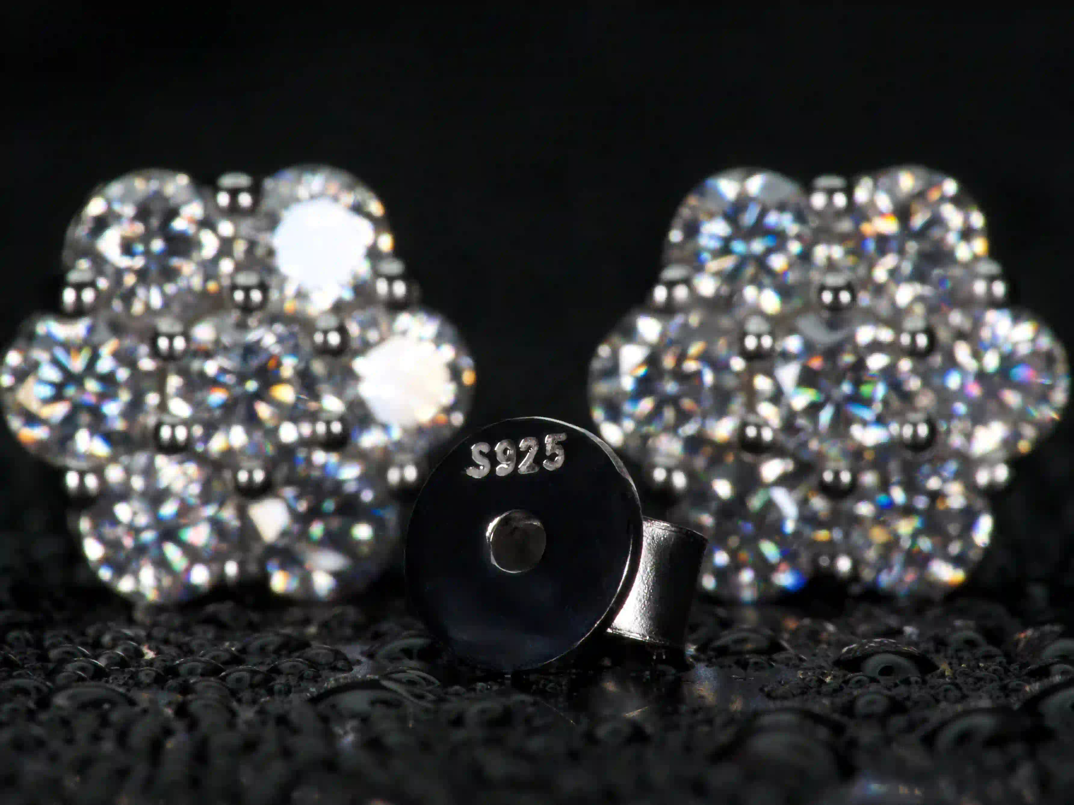 Detailaufnahme des 925 Silber Stempels bei Moissanite Ohrsteckern, Cluster Design im Hintergrund sichtbar, echte Verarbeitung und Materialqualität, Makroaufnahme ohne Filter