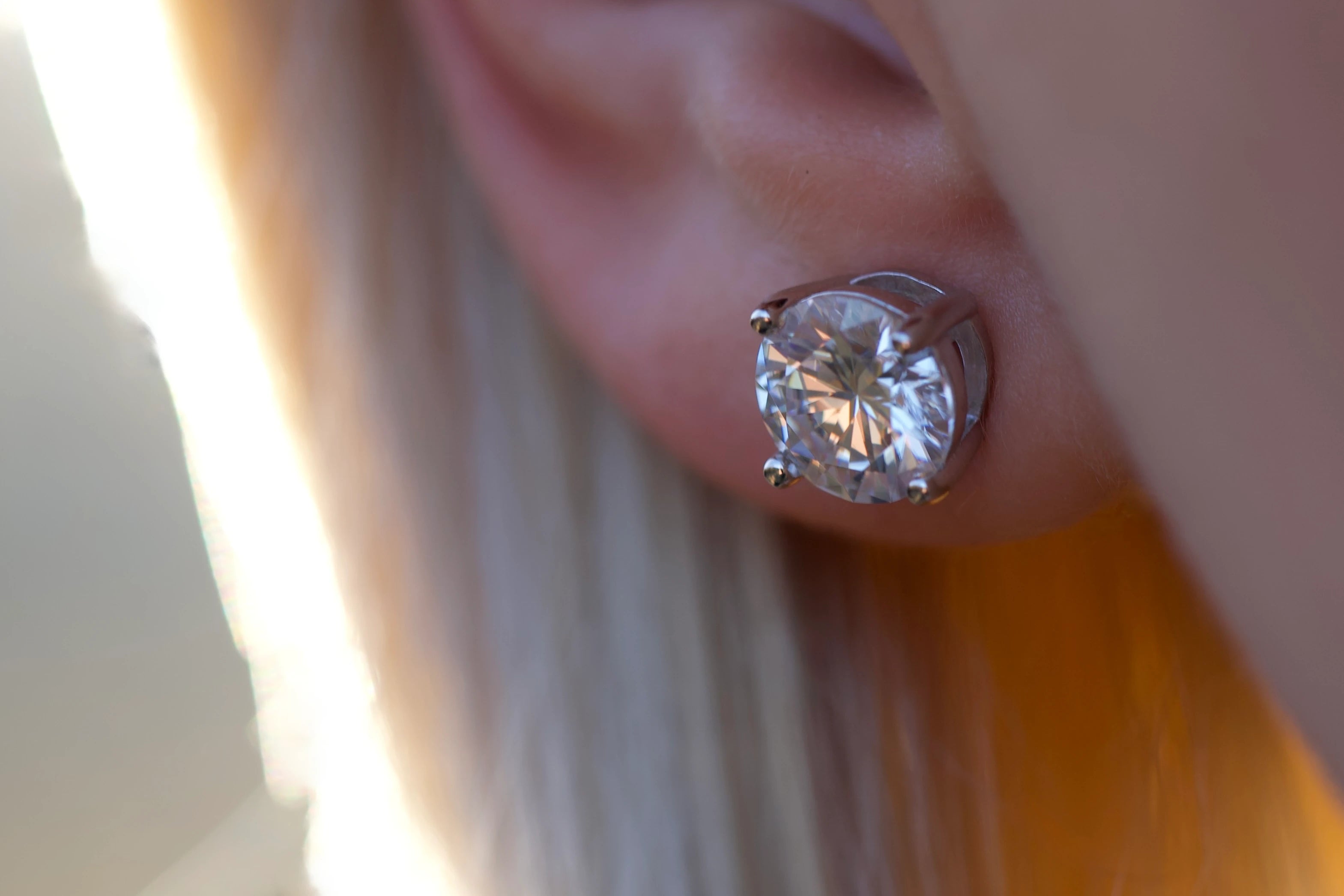 Getragene Moissanite Ohrstecker in der Sonne am Ohr mit lebendigem Funkeln im Alltag, wirken wie Diamant, echte Fotos ohne KI zeigen echtes Lichtverhalten